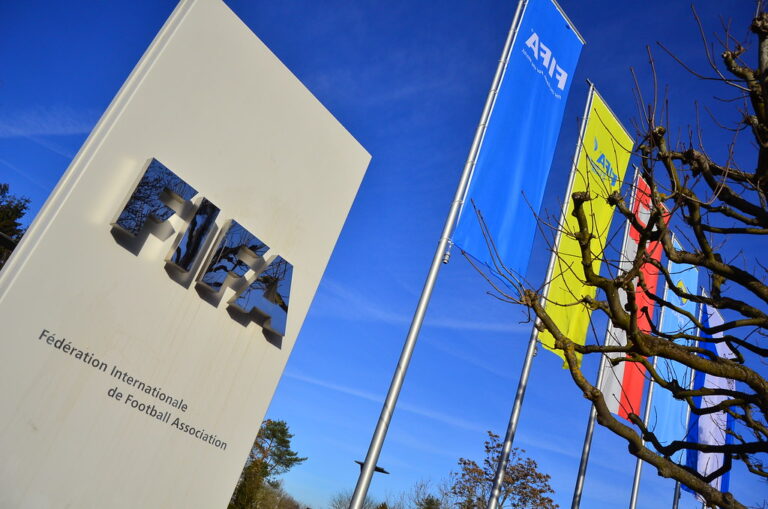 “Fifa logo and flags at Fifa headquarters, Zurich” by Ben Sutherland, CC BY 2.0